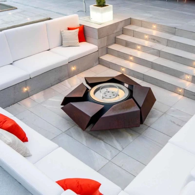 Stravaganza firepit by GlammFire in lacquered corten steel, a luxury outdoor fire feature with a rust-toned finish.