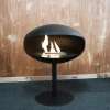 Cocoon Pedestal - Black with a Black Base, a freestanding bioethanol fireplace with a modern design and eco-friendly heating.