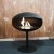 Cocoon Pedestal - Black with a Black Base, a freestanding bioethanol fireplace with a modern design and eco-friendly heating.