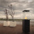 Lighthouse Outdoor Fireplace in black with manual control, designed for outdoor heating and ambiance.