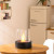 Planika Lotus tabletop bioethanol fireplace in black with a sleek, modern design, offering 3.5 hours of burn time and 2.5 kW hea